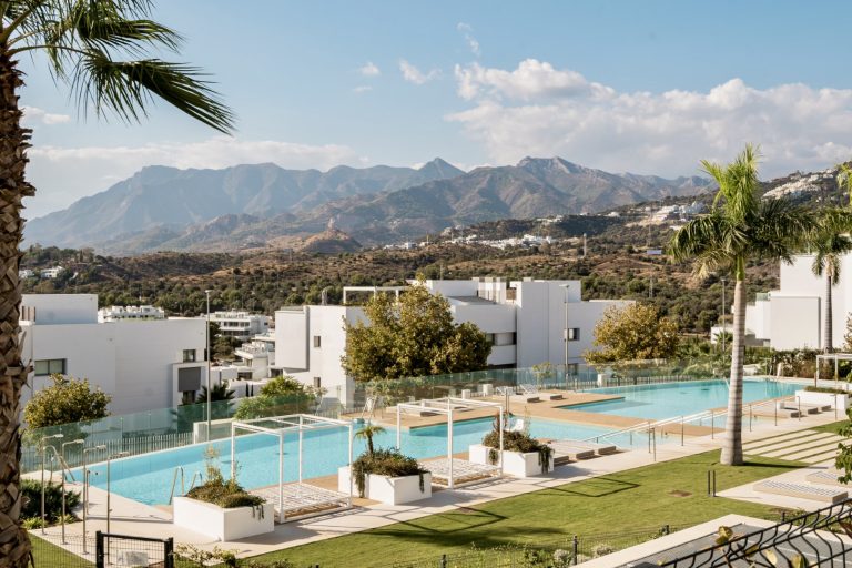Modern communal swimming pool at Soul Marbella with sun loungers and landscaped gardens